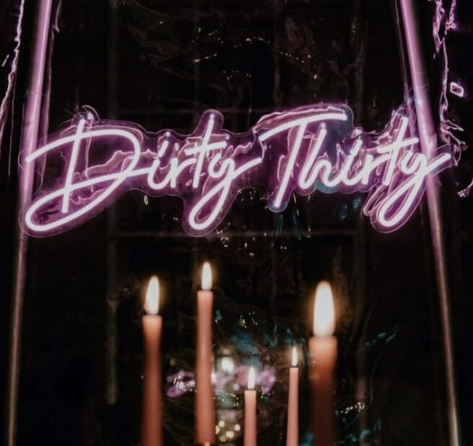 dirty thirty birthday party neon sign with candles